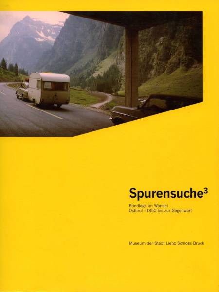 Ein gelbes Cover mit dem Titel „Spurensuche“ und einem Foto eines Wohnmobils in einer Berglandschaft.